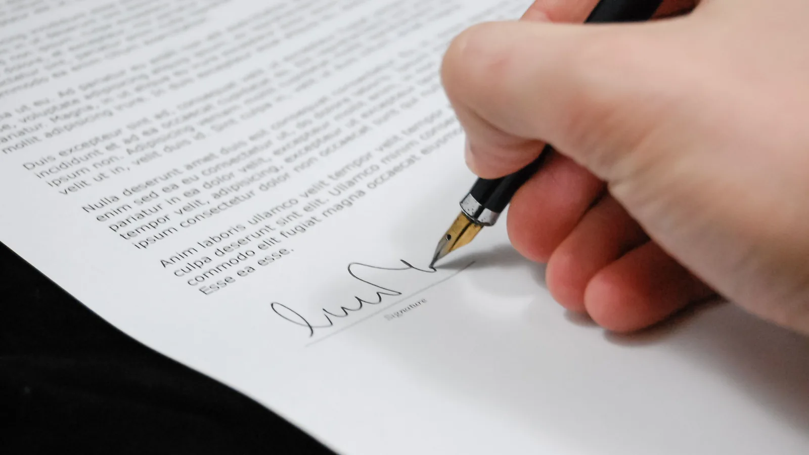 Close-up of a contract being signed with a fountain pen