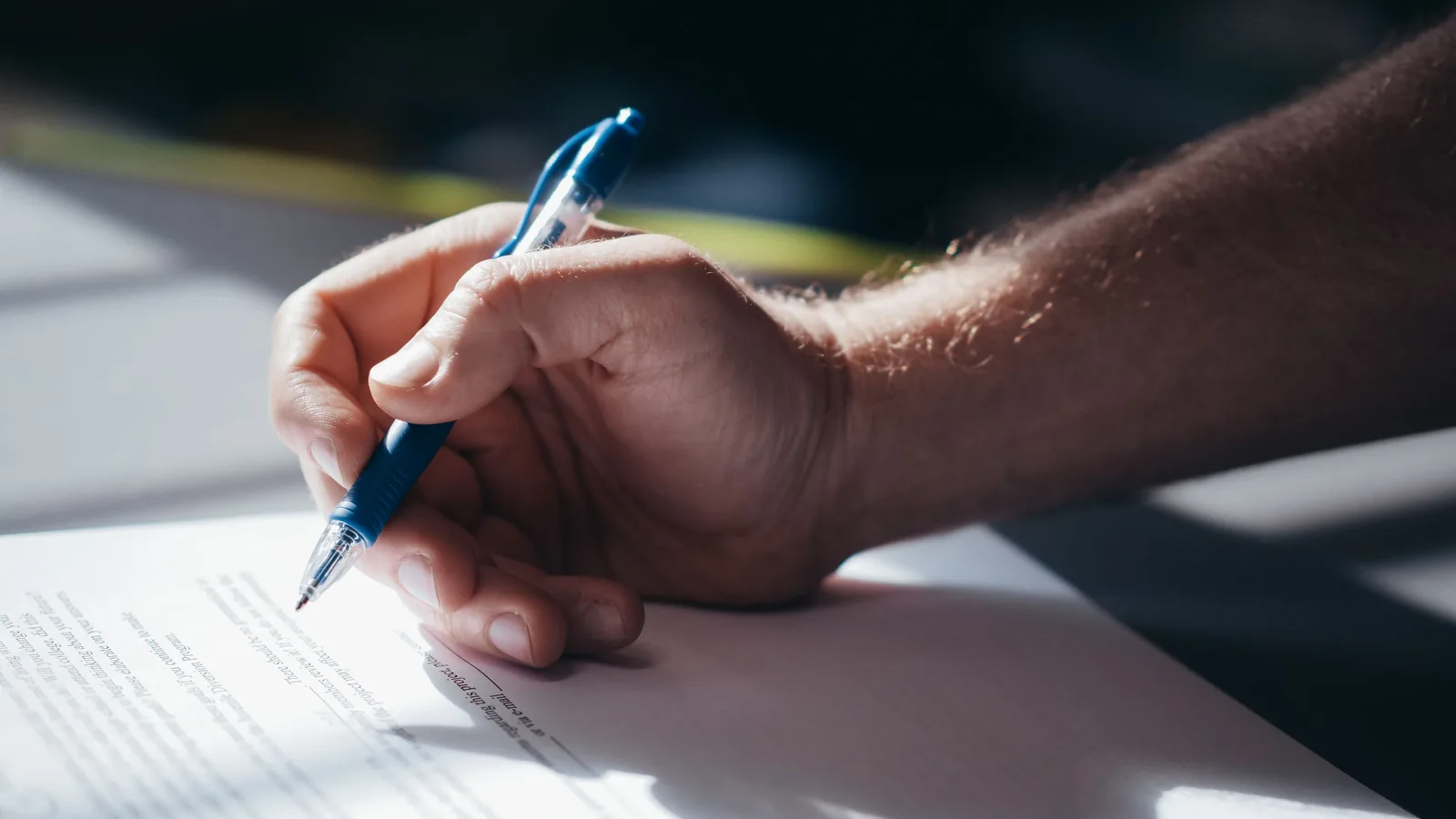Close-up of a person writing on a document