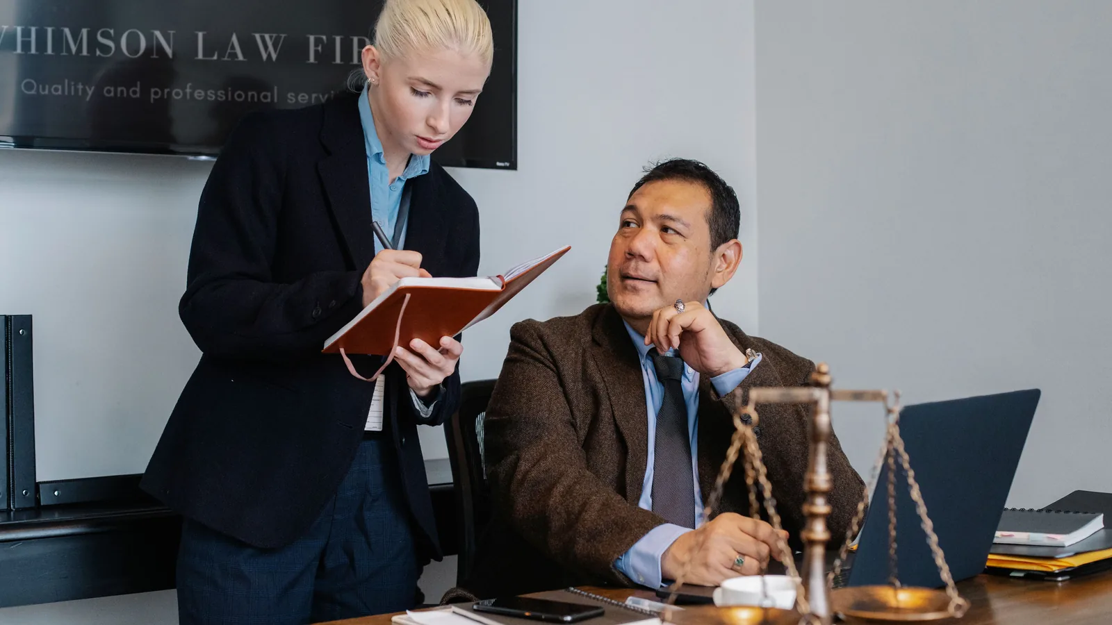 Legal professional taking notes during an office consultation