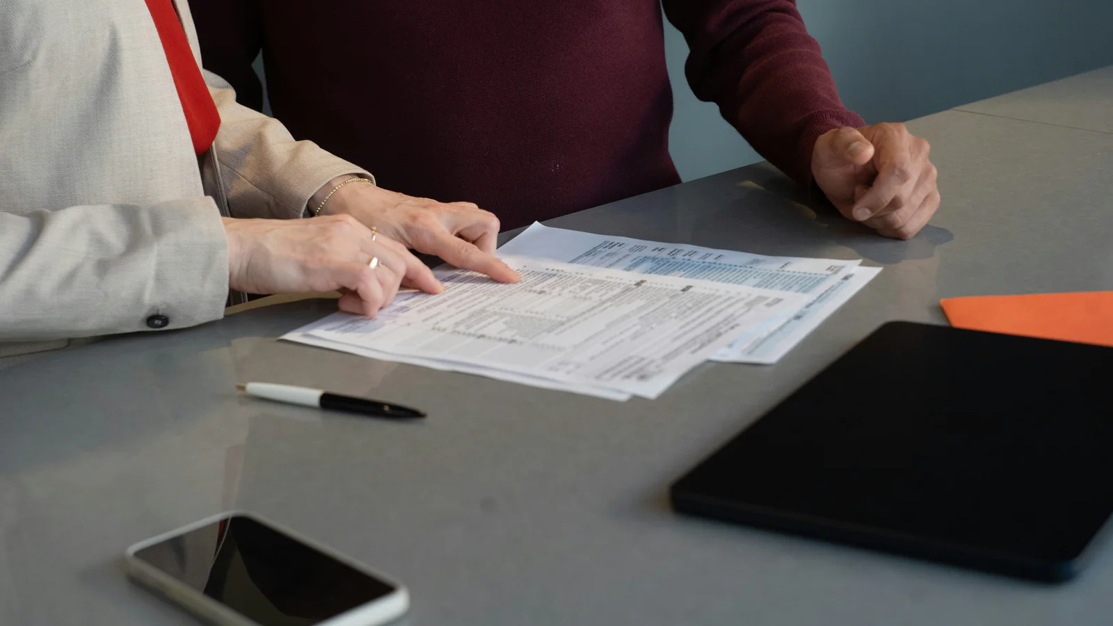 Professionals reviewing neutral company records at a meeting table