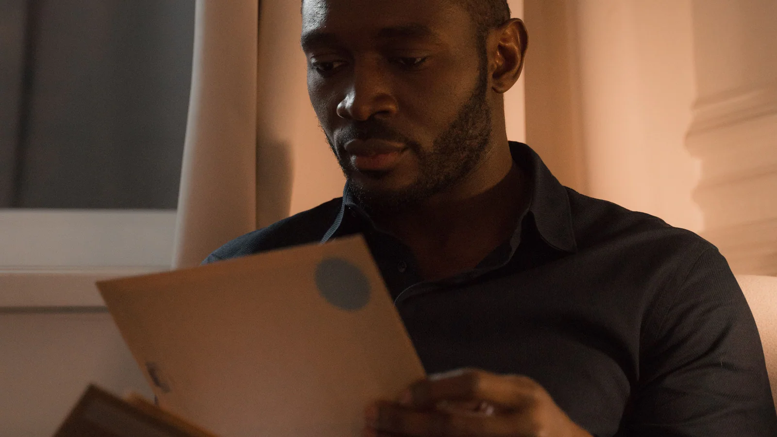 Man reviewing correspondence while seated indoors