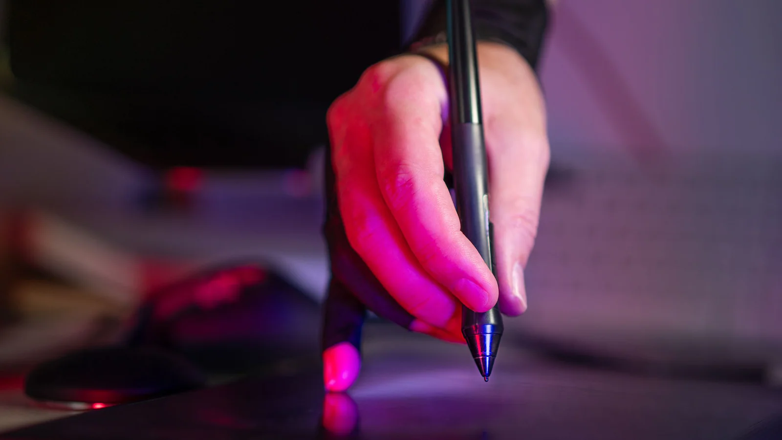 Hand using a stylus on a digital drawing tablet