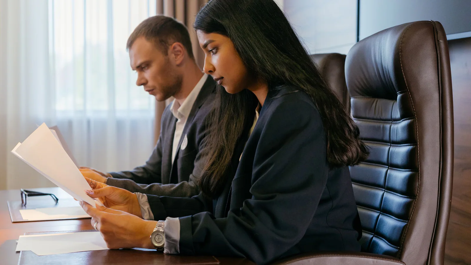 Two professionals reviewing documents at an office table
