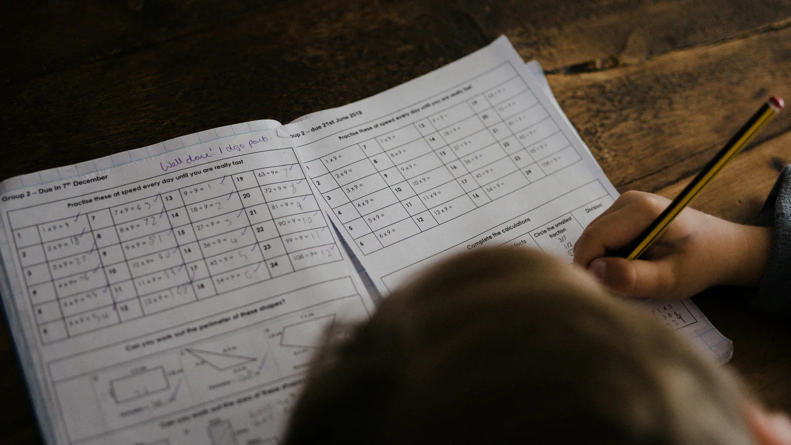 Child writing in a book at a desk