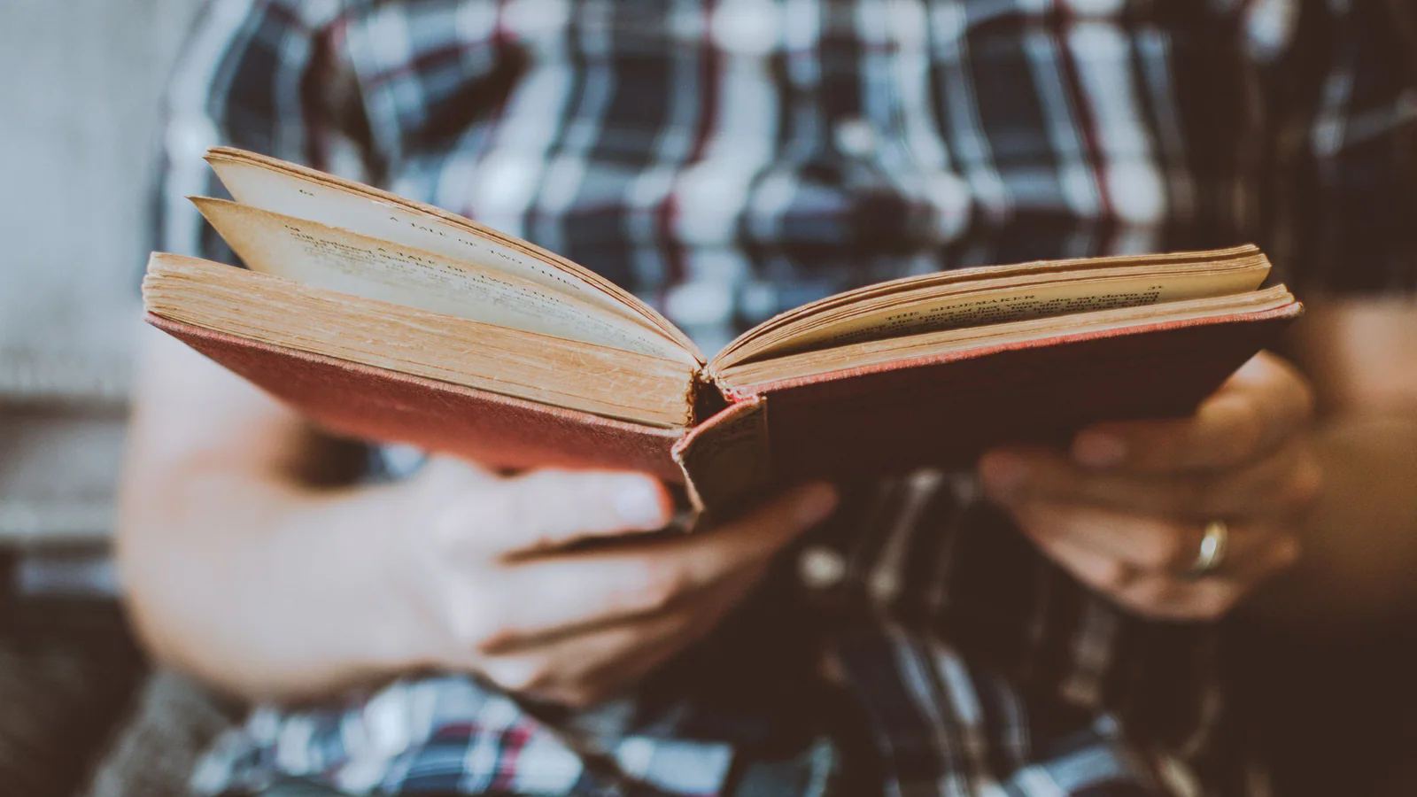 Two people holding an open book together