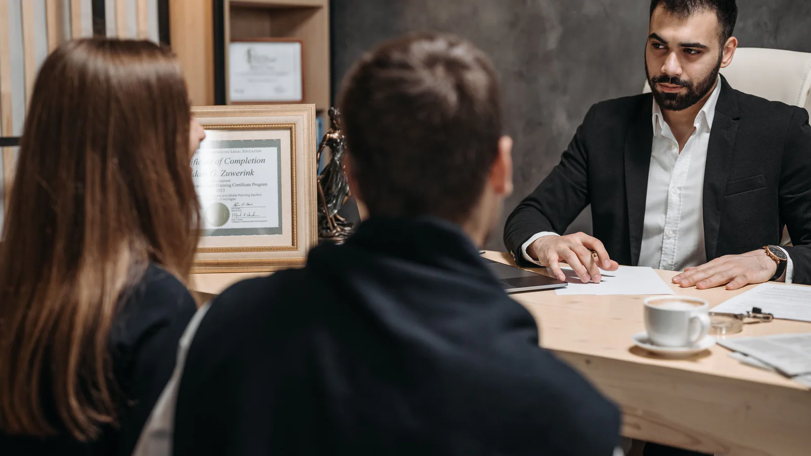 People discussing documents across an office desk
