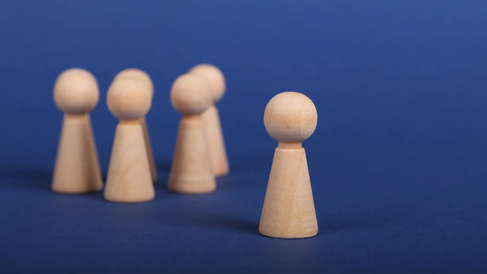 Wooden figures arranged on a blue background