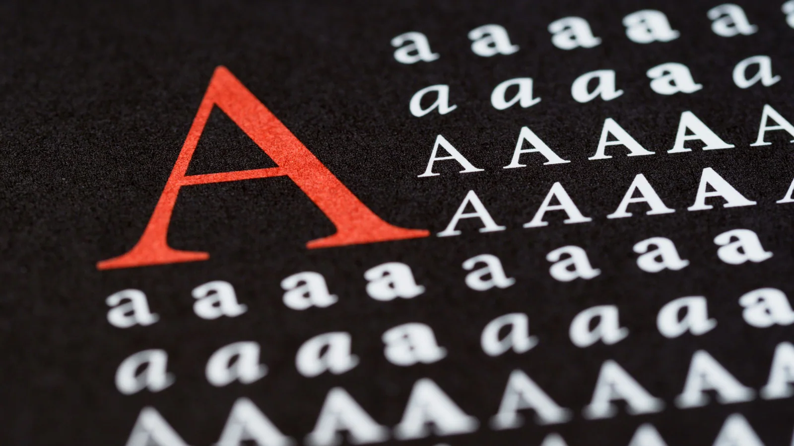 Uppercase and lowercase letter A forms printed on a black surface