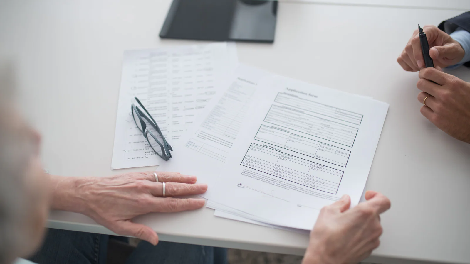 Hands reviewing documents together at an office table