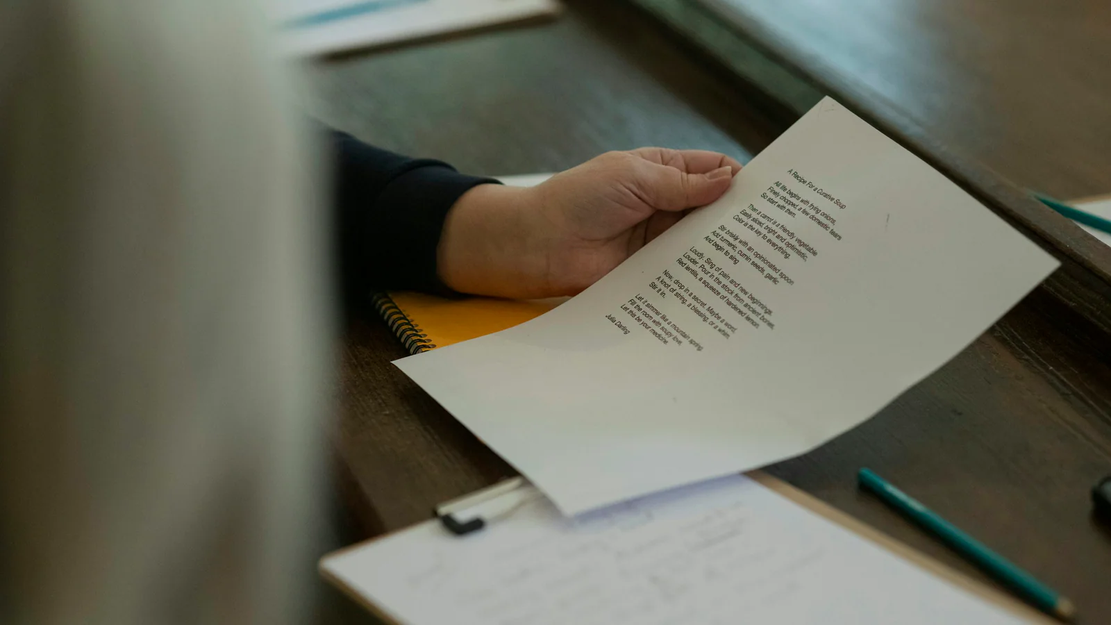 Hands reviewing a paper at a desk as a disciplinary-hearing evidence metaphor