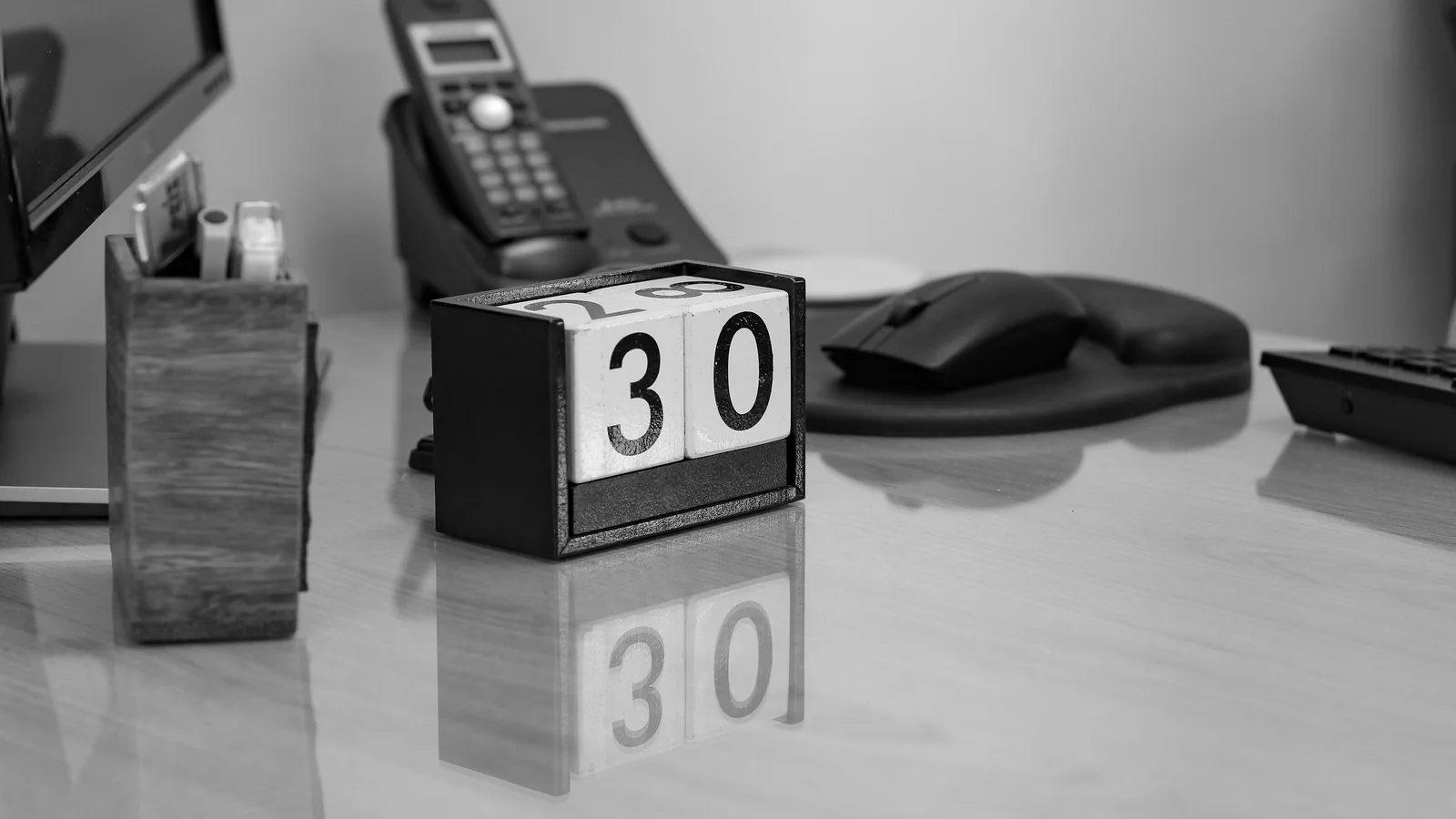 Perpetual calendar showing 30 on a monochrome office desk