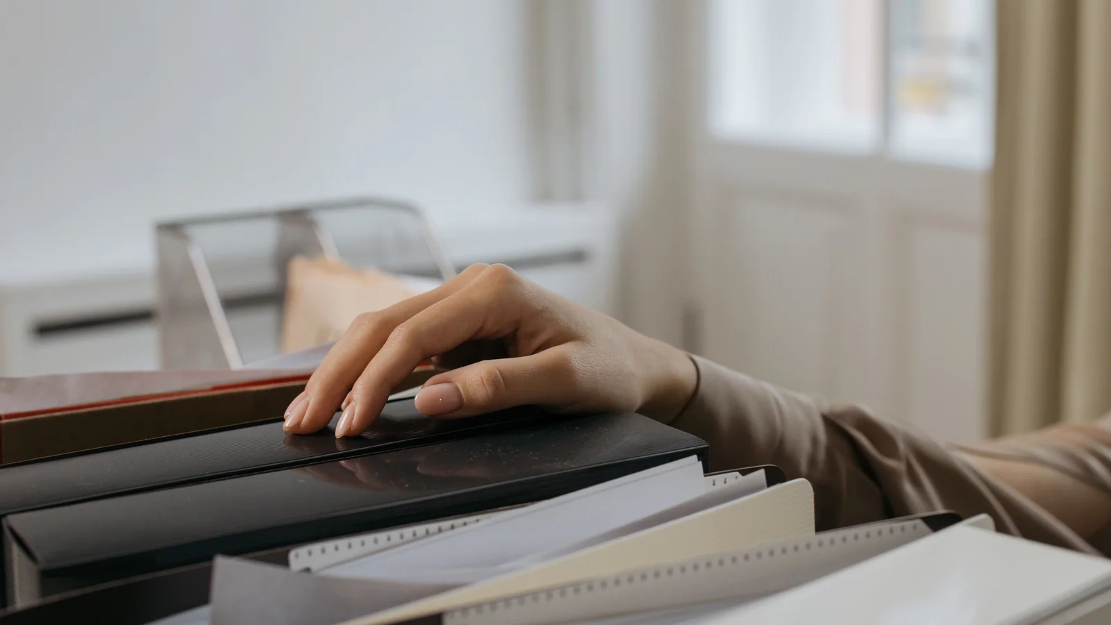 Hand selecting an unlabelled folder from an office filing box