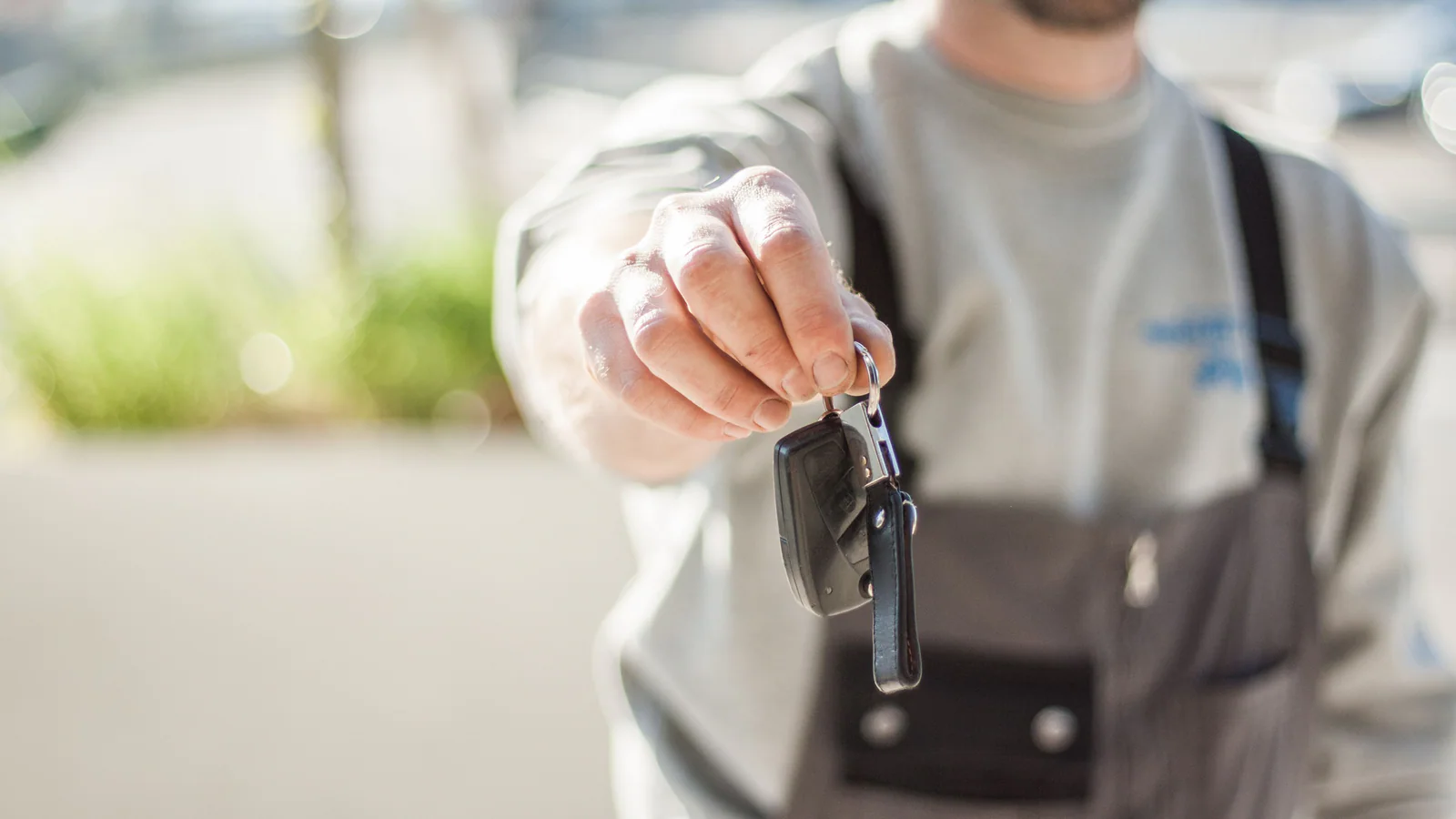 A person holding out an unbranded set of car keys