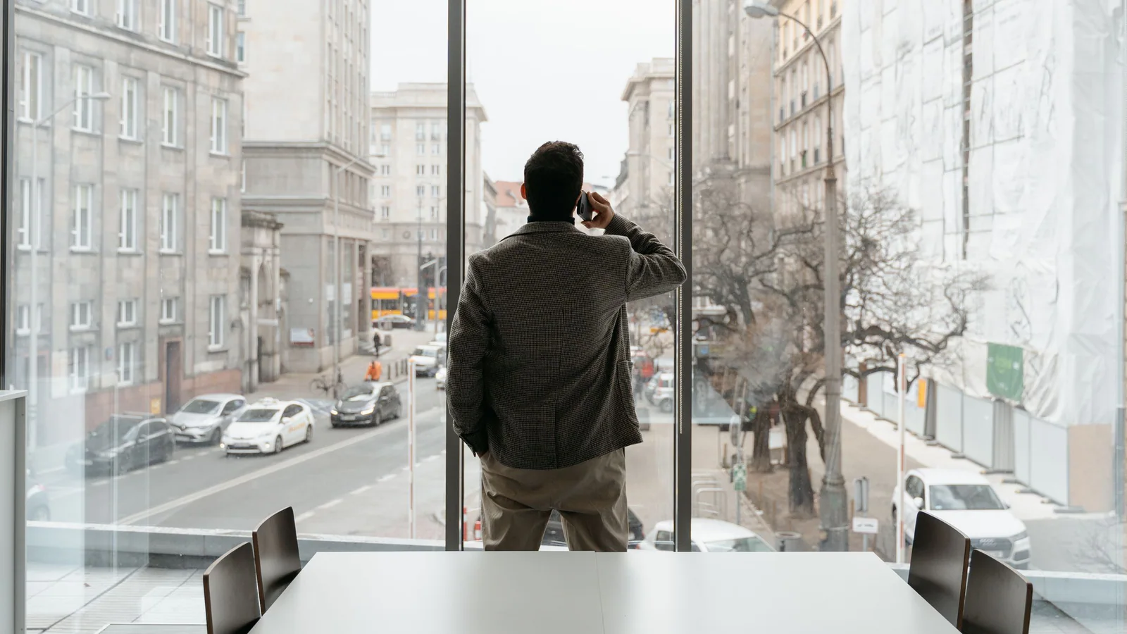 Person on a phone call facing an office window
