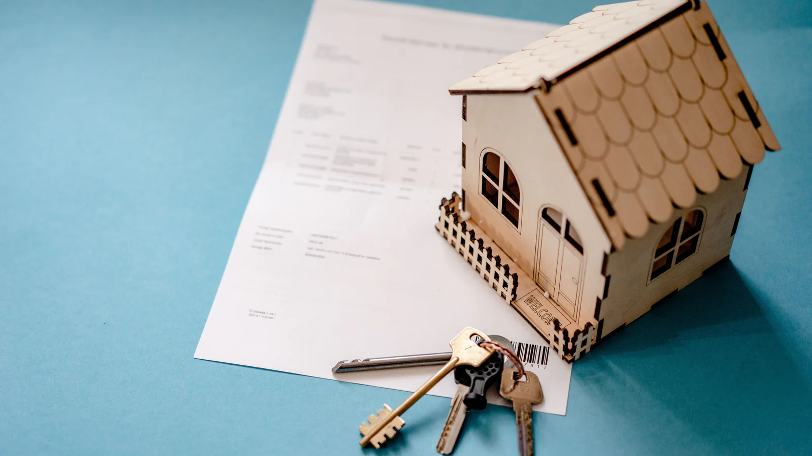 House model, keys and generic property documents on a table