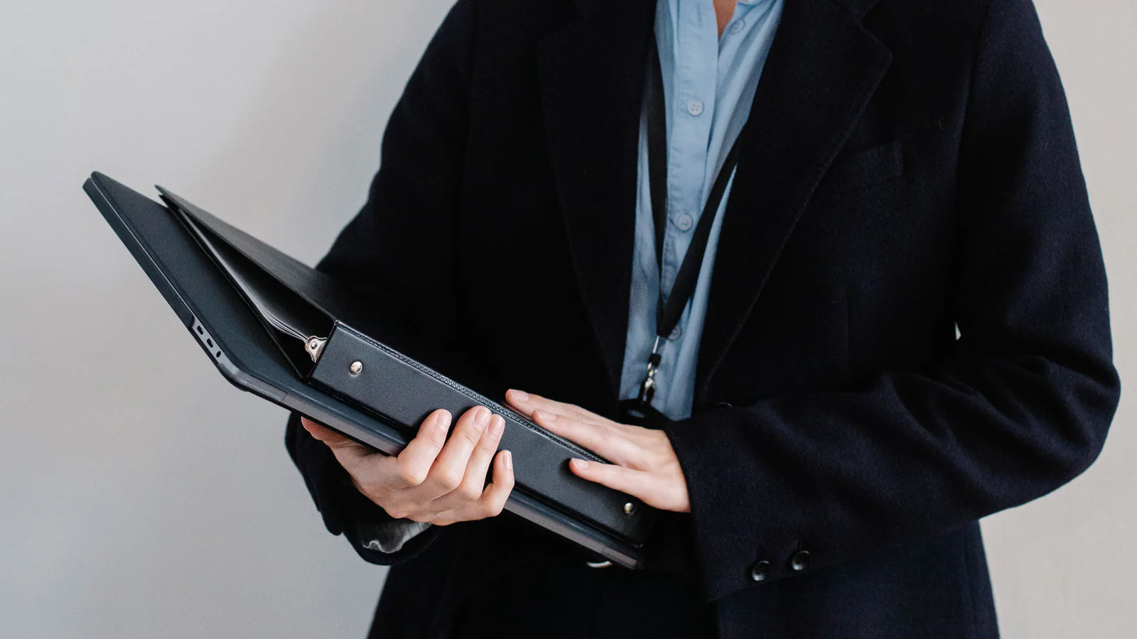 Unidentifiable professional holding a closed black folder