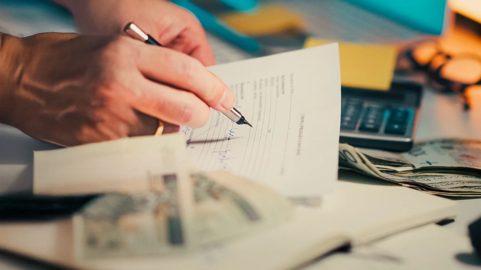 Hand reviewing financial documents with a calculator