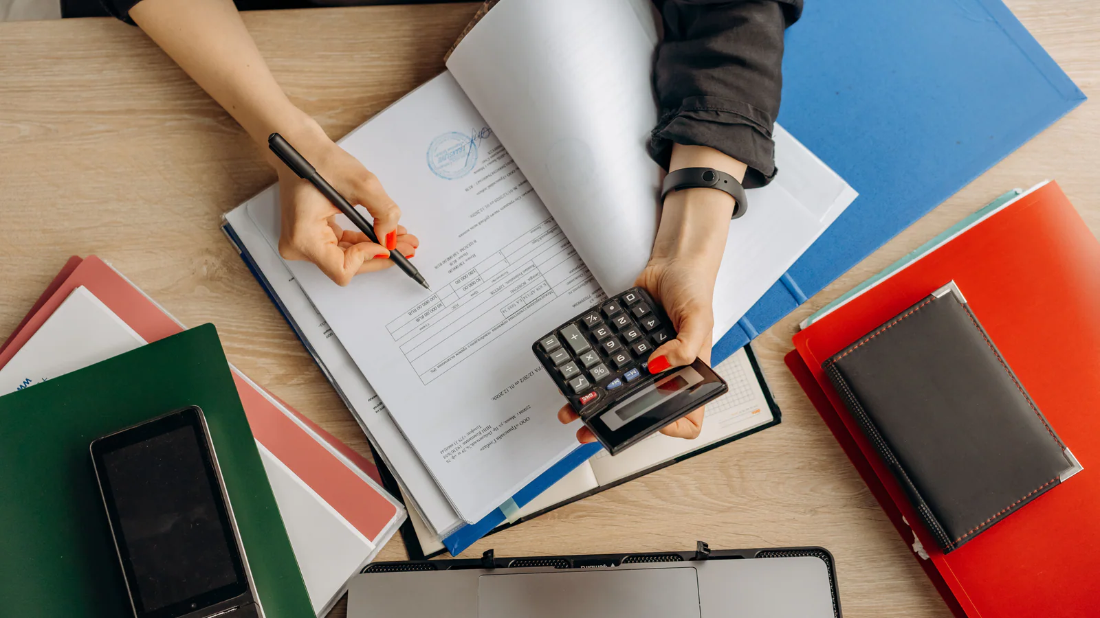 Person reviewing financial documents with a calculator