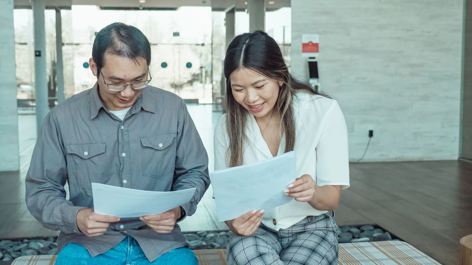Two colleagues reviewing printed material together at an office table