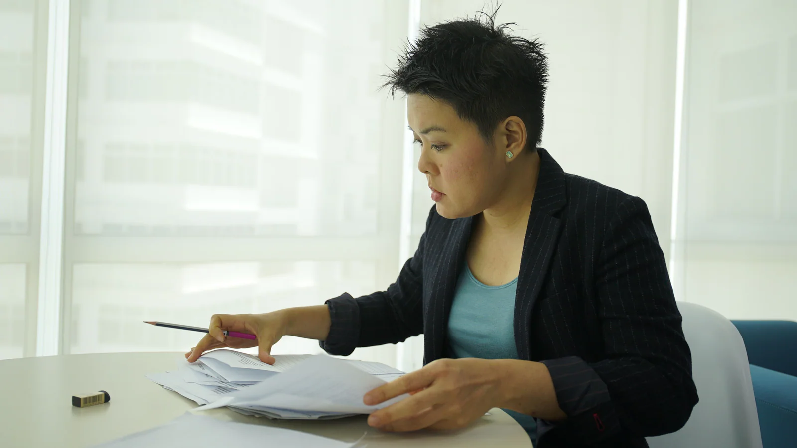 Professional reviewing documents at a bright office table