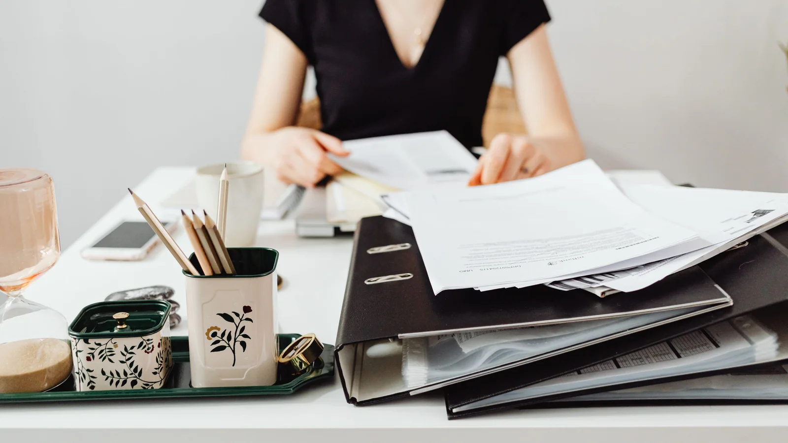 A person sorting folders and documents at a desk