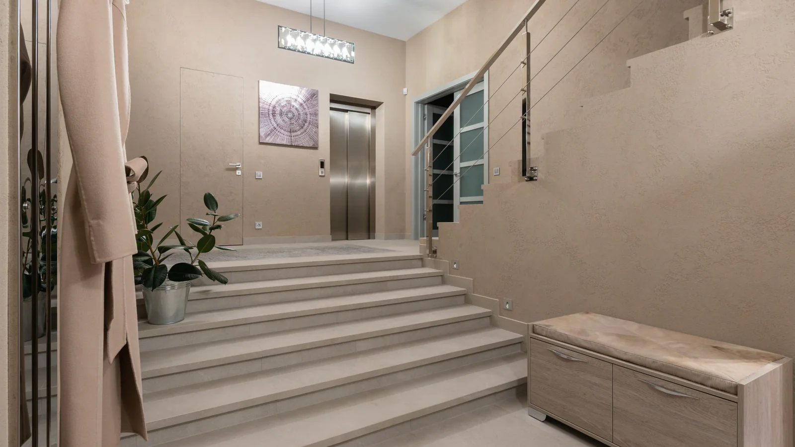 Empty beige apartment lobby with steps and a lift