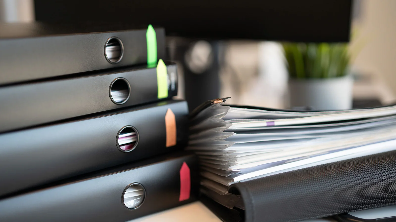Black ring binders and an open document folder in an office