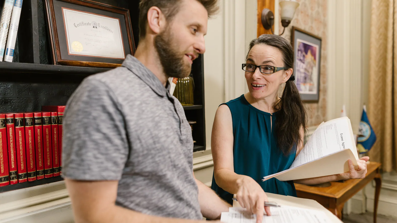 Two professionals discussing documents in an office