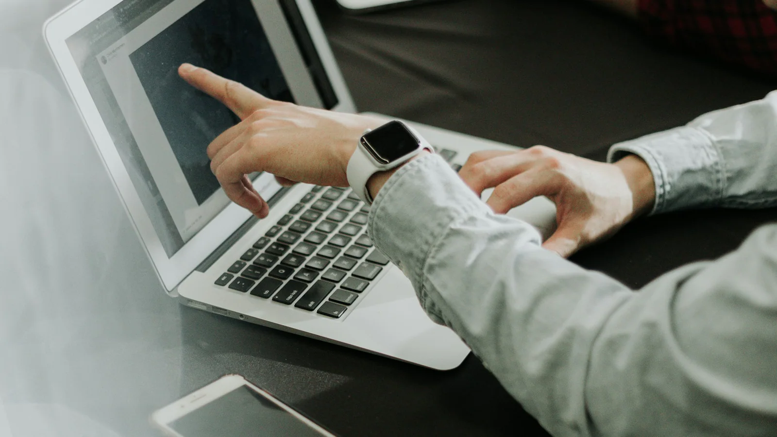 Two people discussing information on a laptop during a consultation