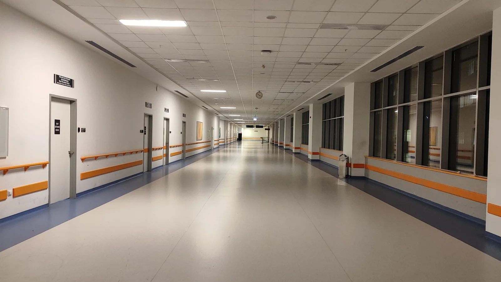 Empty hospital corridor with closed treatment-room doors
