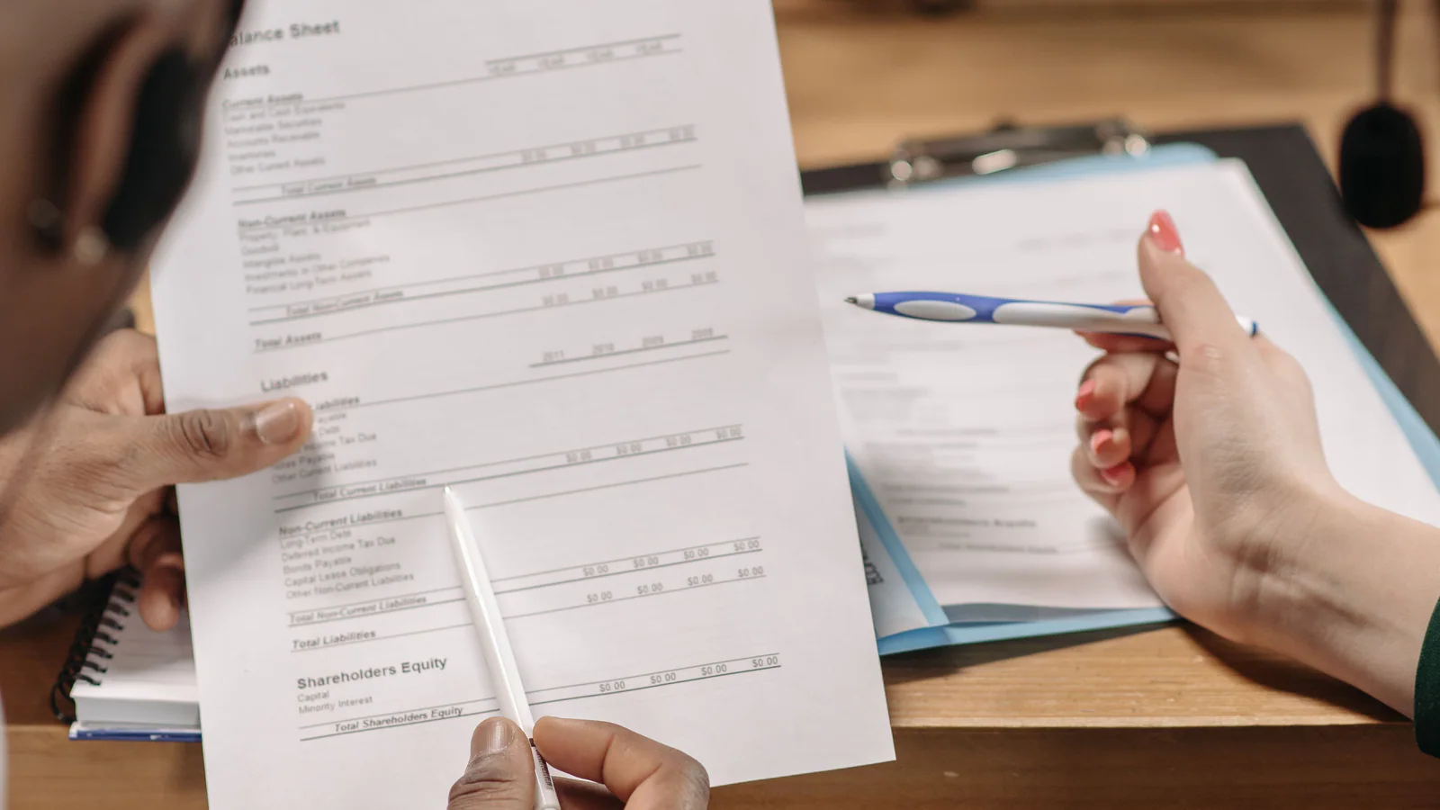 Two people reviewing a financial document across an office desk