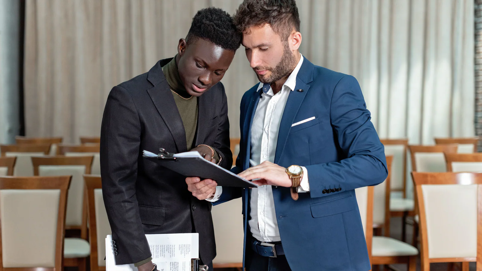 Two professionals reviewing a document together at a conference table
