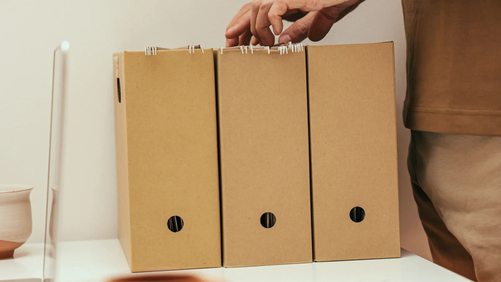 A person organising plain paper files at a desk