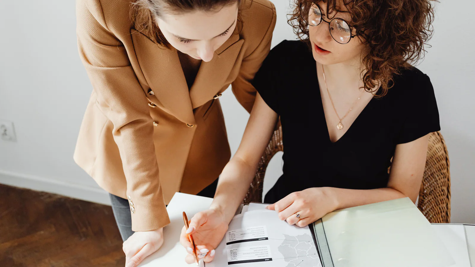 Two professionals reviewing printed information at a table