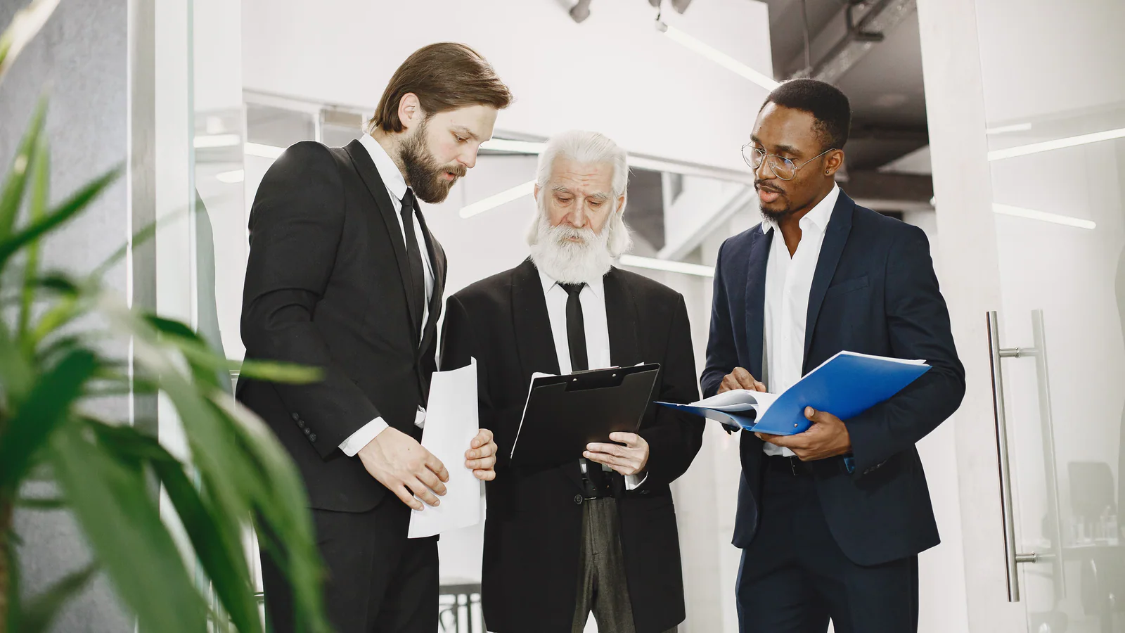 Three professionals reviewing documents together in an office