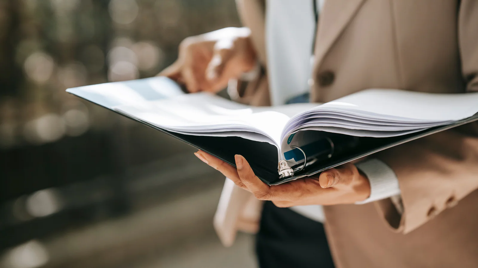 Person reviewing documents in an open ring binder