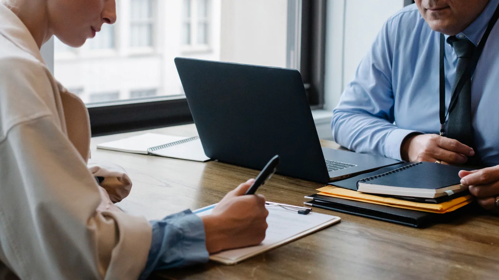 Two adults reviewing papers and notes during an office meeting