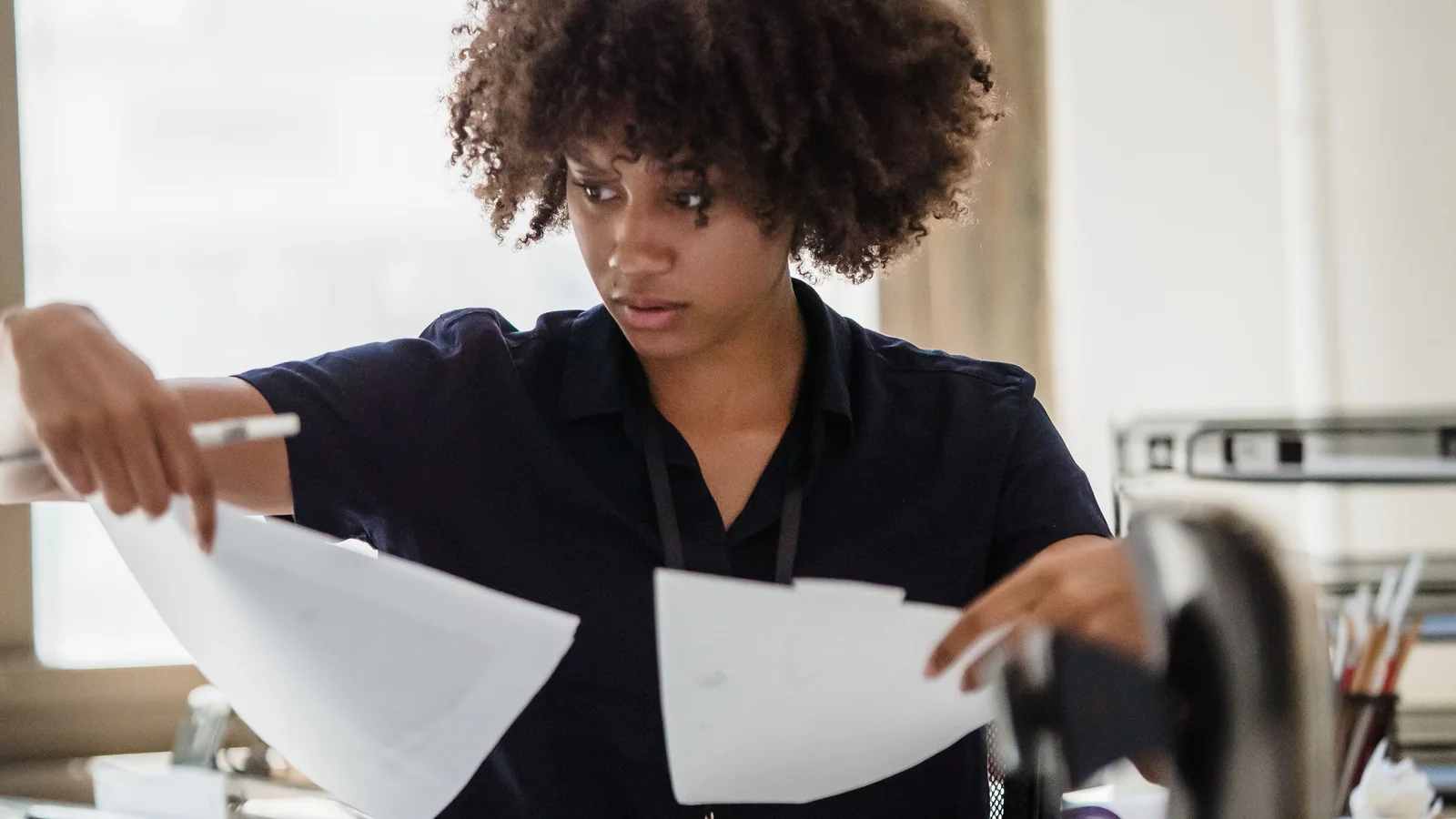 Person comparing several papers at an office desk