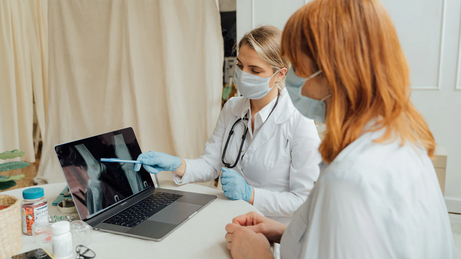 Two healthcare professionals reviewing an X-ray on a laptop