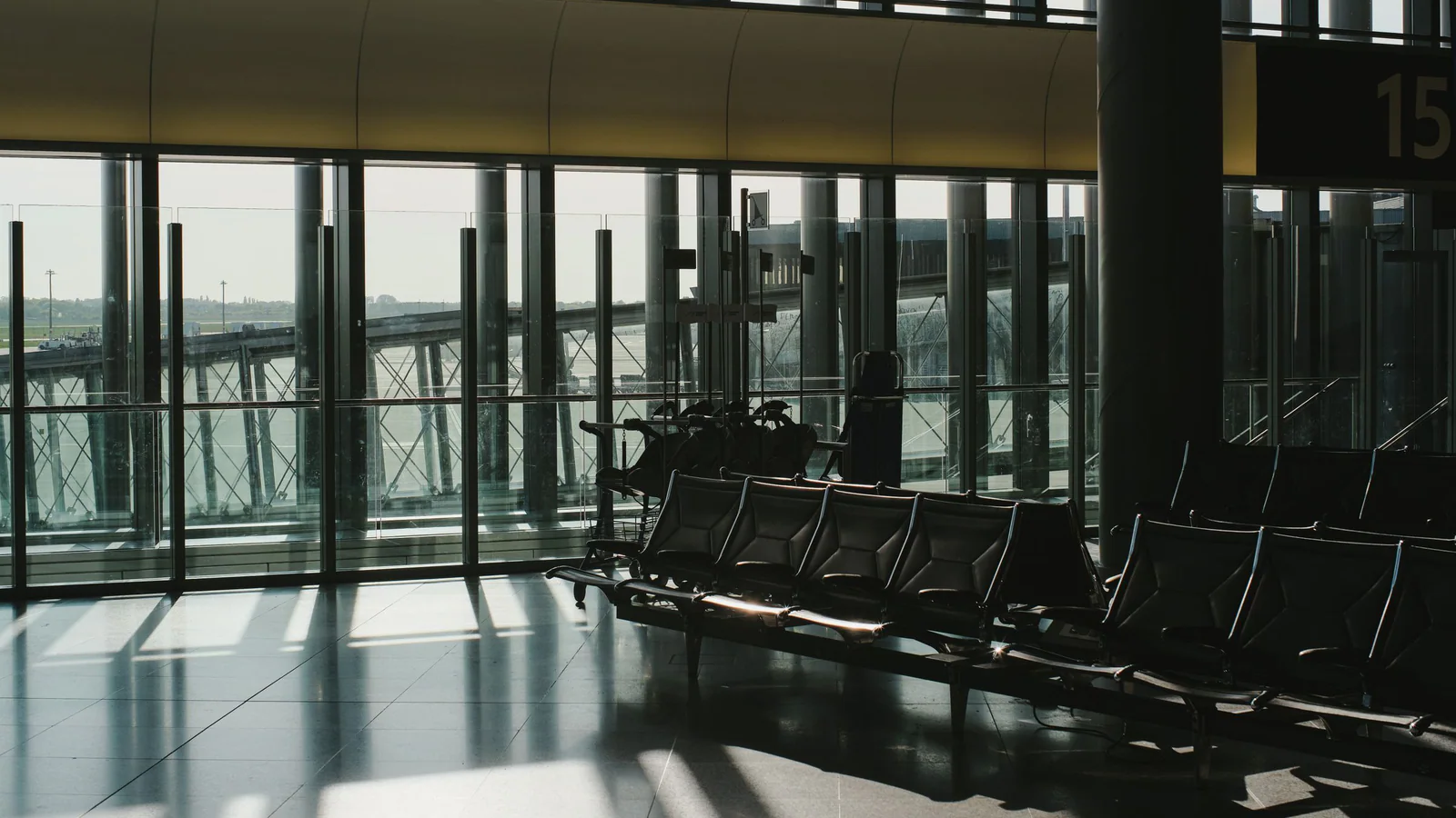 Empty airport terminal seats beside sunlit windows
