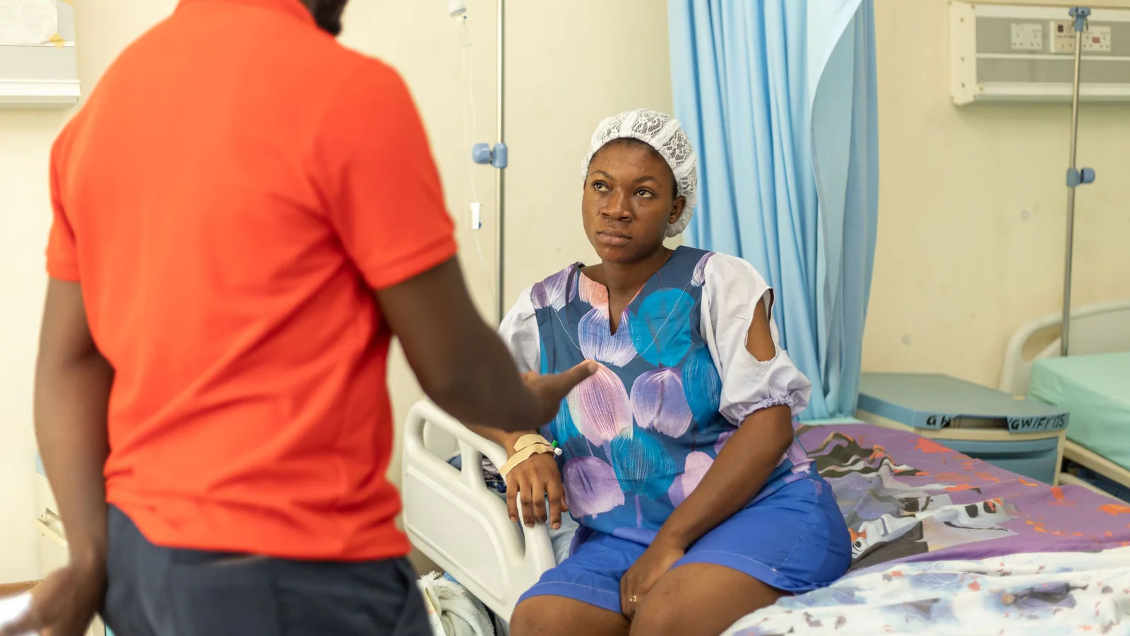 Two people talking in a hospital room
