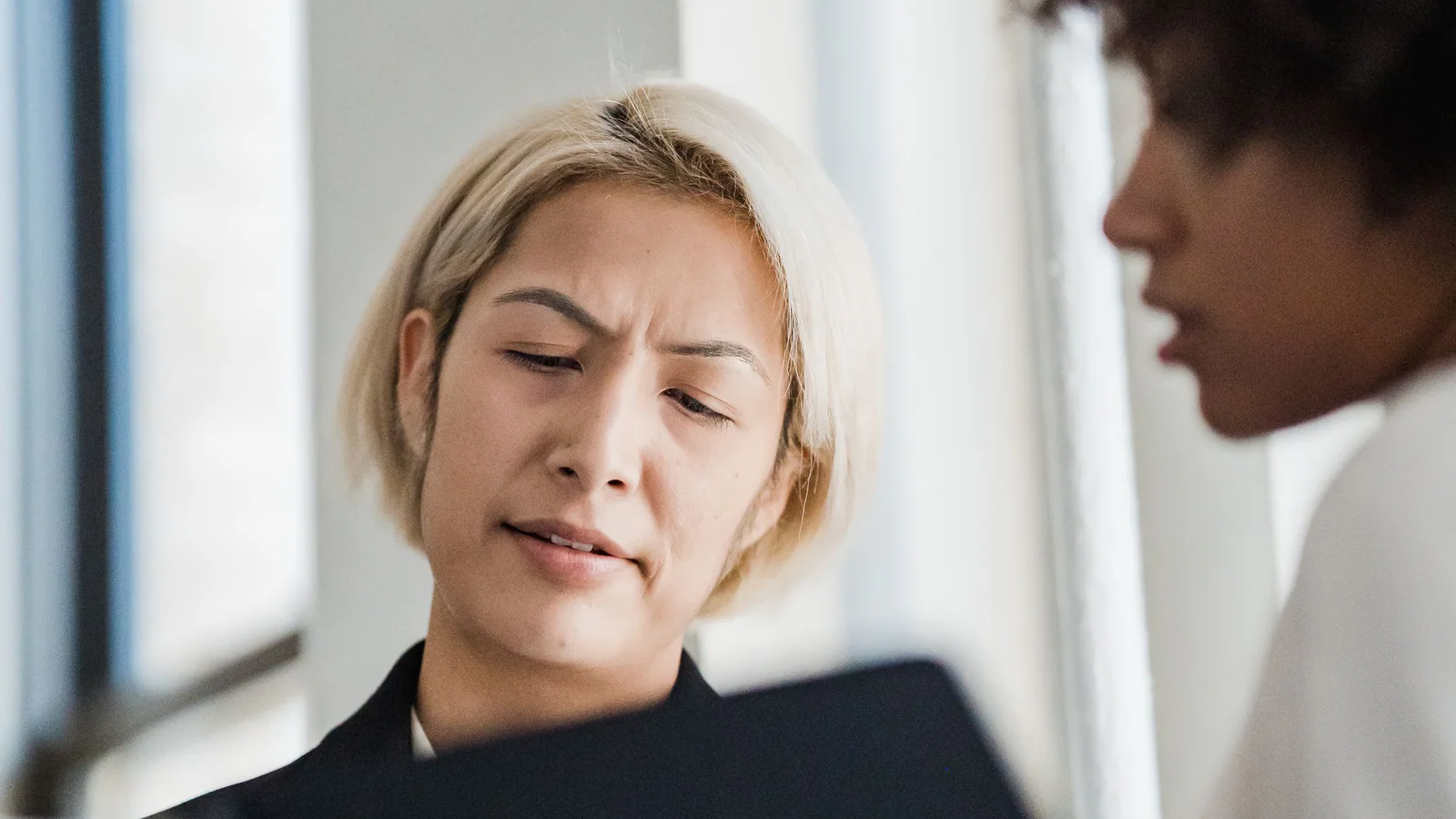 Two people reviewing printed documents together at an office desk