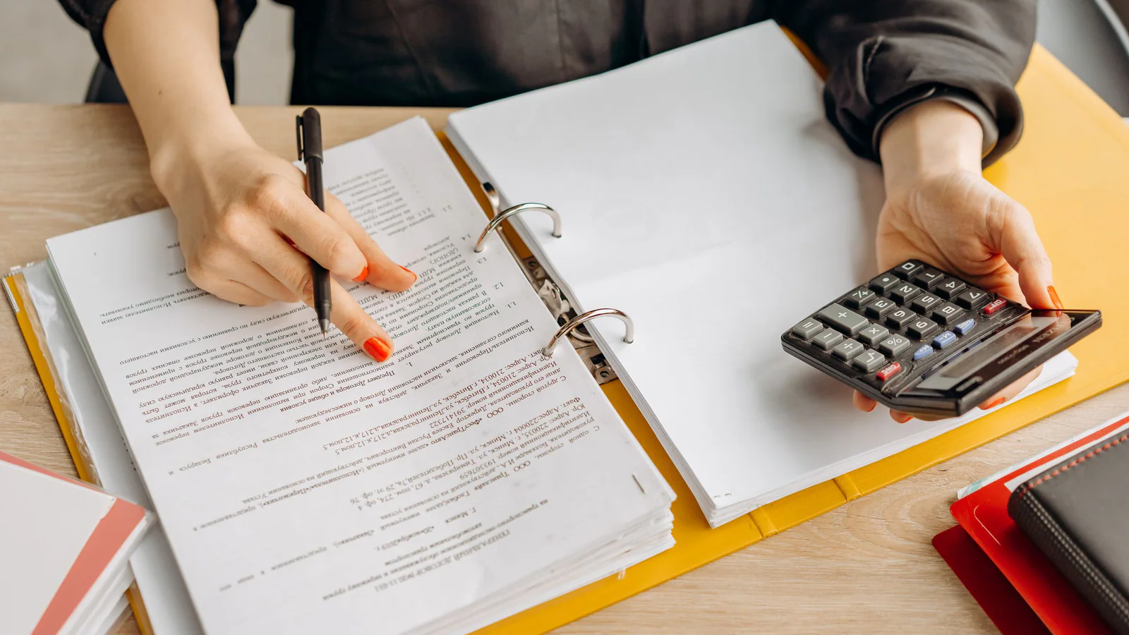 Person reviewing a document with a calculator at a desk