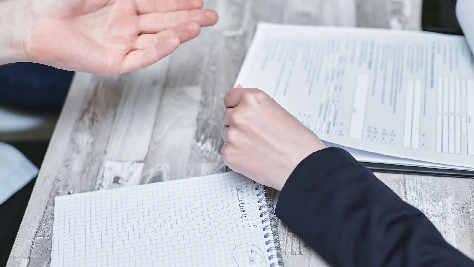 Two people discussing documents at an office table