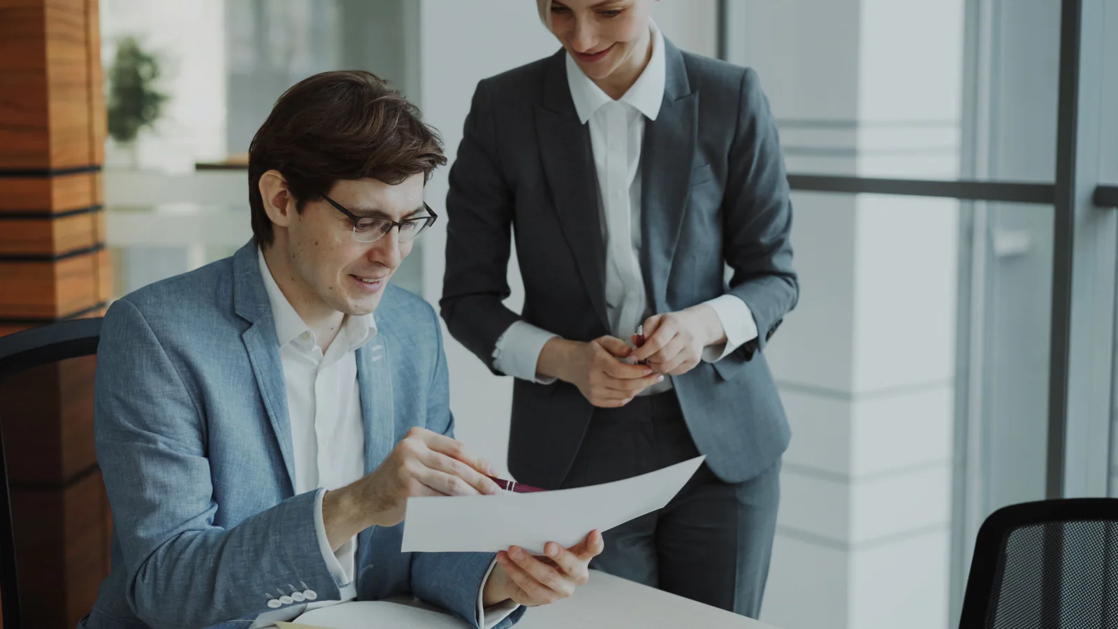 Two adults reviewing a blank document in a modern office
