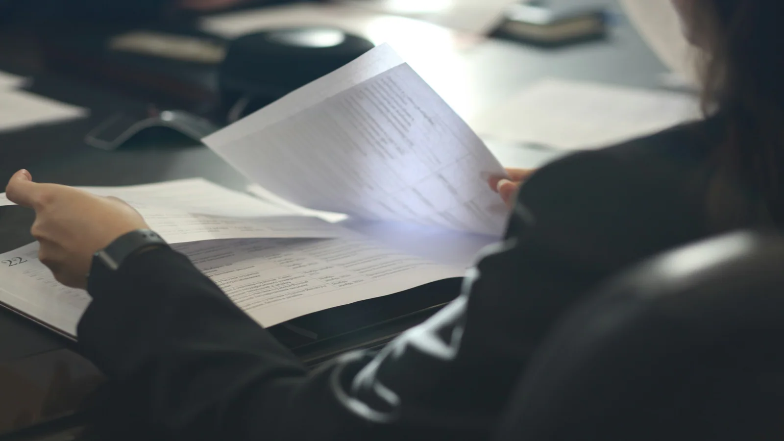 Person reviewing printed documents at a meeting table