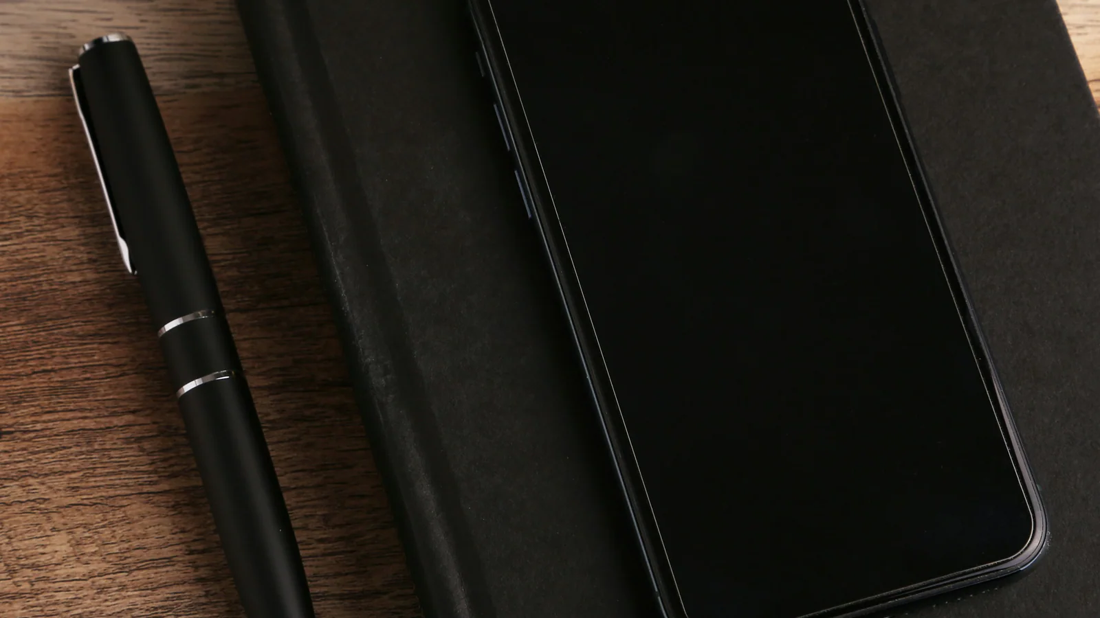 Blank smartphone and notebook arranged on a desk