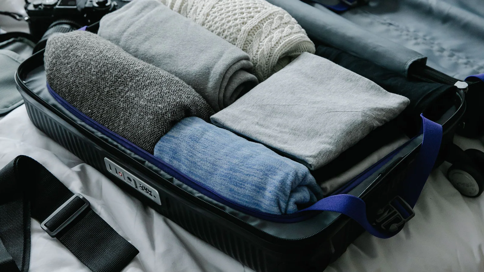 Open suitcase with neatly folded clothes ready for travel
