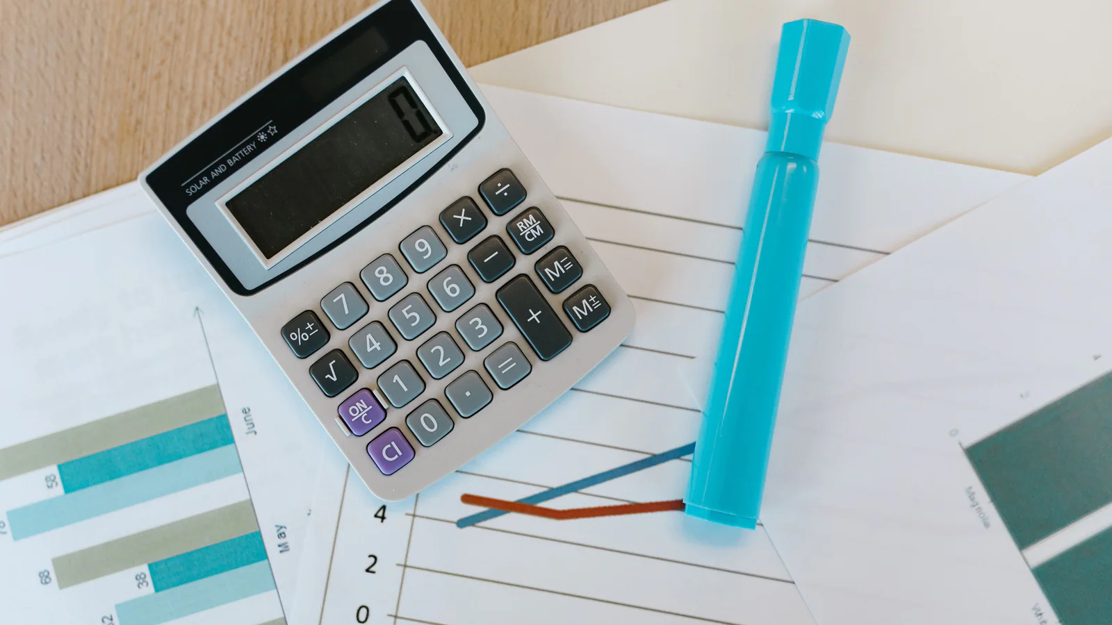 Calculator and marker resting on printed charts
