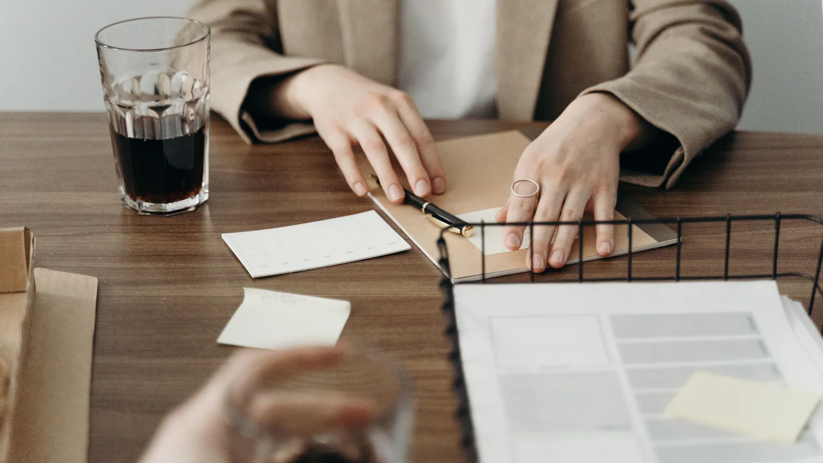 Two people organising papers around a folder
